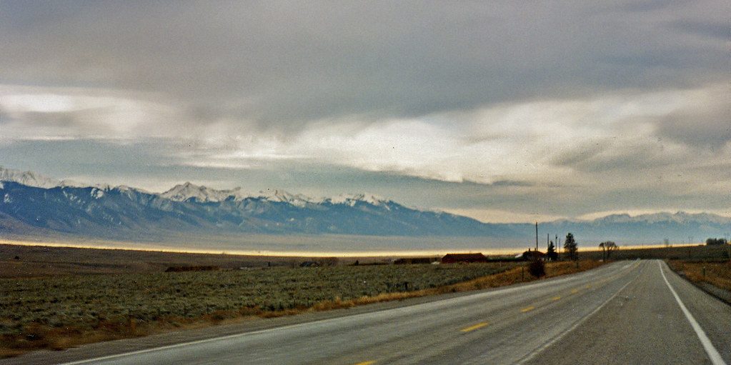 An open highway running toward distant mountains
